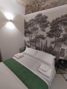 ein Schlafzimmer mit einem weißen Bett mit Wandmalereien in der Unterkunft A CASA DEI ROMANI in Rom