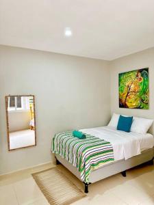 a bedroom with a bed with a painting on the wall at Beachfront Flat Brickell@LaCosta in El Zapote