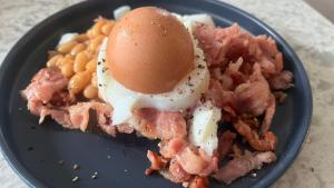 a plate of food with an egg on top of pasta at Soul Oasis Urban Retreat in Centurion