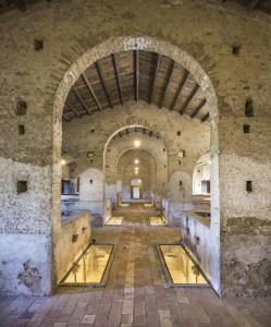 ein großes Steingebäude mit einem Torbogen in einem Gebäude in der Unterkunft Wine Relais Feudi Del Pisciotto in Niscemi
