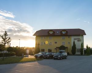 un hotel con tres coches estacionados en un estacionamiento en B&B Bau, en Maribor