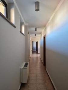 um corredor com paredes brancas e piso em azulejo em Manfredi ristorante con alloggio em Romentino