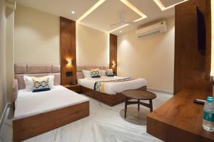 Cette chambre comprend 2 lits et une table. dans l'établissement The Sky Imperial Hotel Sugam - 10 Meters from Shrinathji Temple, à Nathdwara