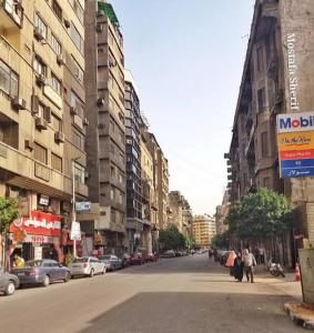 eine Stadtstraße mit Gebäuden und Menschen, die die Straße hinuntergehen in der Unterkunft My place agata Hostel in Kairo