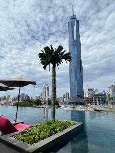 a pool with a palm tree and a tall building at Opus Residences KL 118 View in Kuala Lumpur