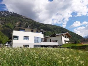 a white house in front of a mountain at Appartement Falkner Manuel in Niederthai