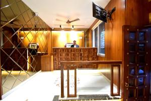 a man sitting at a bar in a room at The Sky Imperial Hotel Sugam - 10 Meters from Shrinathji Temple in Nāthdwāra