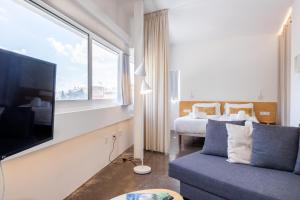 a living room with a couch and a tv and a bed at Home2Book Casablanca Las Teresitas Beach in San Andrés