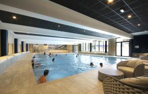a large swimming pool with people in it at Appart'Hôtel Prestige Odalys L'Eclose in L'Alpe-d'Huez