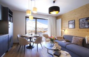 een woonkamer met een bank en een tafel bij Appart'Hôtel Prestige Odalys L'Eclose in L'Alpe-d'Huez