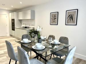 a dining room with a glass table and chairs at Luxury 3 Bed House w Parking & Garden! 1 in Bournemouth