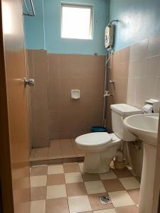 ein Bad mit einem WC und einem Waschbecken in der Unterkunft KUHARA COURT APARTMENT SUITE in Tawau