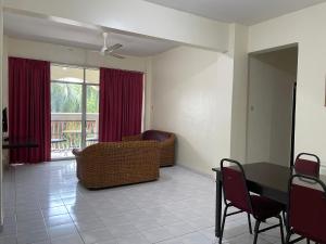 een woonkamer met een tafel en een bank bij KUHARA COURT APARTMENT SUITE in Tawau
