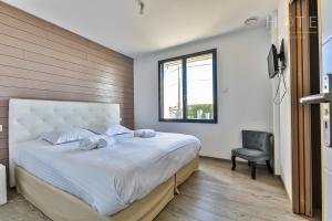 1 dormitorio con 1 cama grande y 1 silla en Grande Villa dans les marais Olonnais, en Olonne-sur-Mer