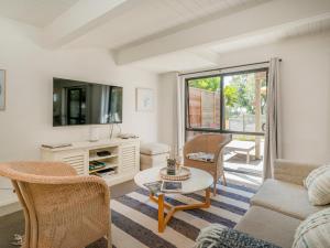 a living room with a couch and a table at Beach Road Beauty - Pauanui Holiday Home in Pauanui