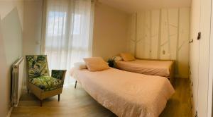 um quarto com duas camas e uma cadeira e uma janela em Apartamento Donostia San Sebastian em Loyola