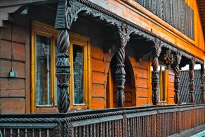 porche delantero de una casa de madera con balcón en Pensiunea Teodora Teleptean en Vadu Izei