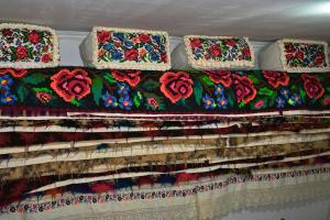 une pile de couvertures sur un mur orné de fleurs dans l'établissement Pensiunea Teodora Teleptean, à Vadu Izei