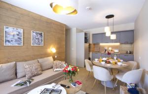 a living room and kitchen with a couch and a table at Résidence Odalys l'Éclose in L'Alpe-d'Huez