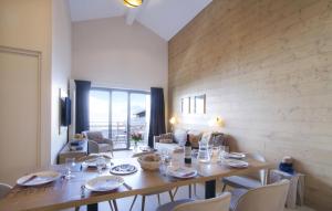 a dining room with a wooden table and chairs at Résidence Odalys l'Éclose in L'Alpe-d'Huez