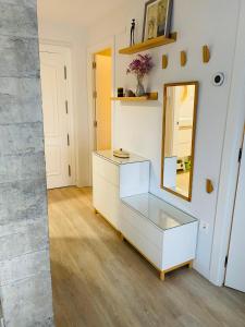 ein Ankleidezimmer mit einem Spiegel und einer Kommode in der Unterkunft Apartamento Donostia San Sebastian in Loyola
