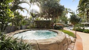 uma banheira de hidromassagem num jardim com palmeiras em Crown Towers Resort - Private 3 Bedroom Apartment em Gold Coast
