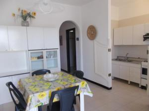 a kitchen with a table with a table cloth on it at Appartamento Eucalpti Baia Verde By Nonsolomare Case Vacanze srlu in Baia Di Gallipoli