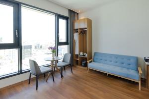 una sala de estar con un banco azul y una mesa en Hotel Arari en Jeonju