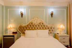 a bedroom with a large bed and two night stands at Super OYO Capital O 1173 Le Grand Hanoi Hotel - The Ruby in Hanoi