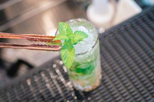 a drink on a bench with a plant in it at Hotel Le Dune in Sampieri