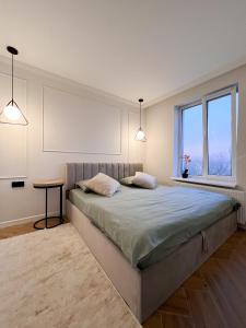 sypialnia z dużym łóżkiem i oknem w obiekcie RentHouse Apartments Neoclassic w Kiszyniowie