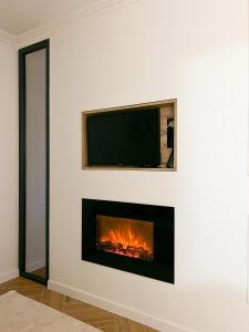 a fireplace in a white wall with a tv above it at RentHouse Apartments Neoclassic in Chişinău