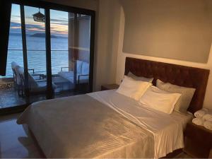 a bedroom with a bed with a view of the ocean at Candi Luxury Suites in Neos Marmaras