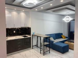 a kitchen with a blue couch and a table at Candi Luxury Suites in Neos Marmaras