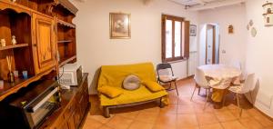 a living room with a yellow chair and a table at BIANCAROSA in Viterbo