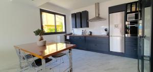 cocina con armarios azules y mesa de madera en Paradise view en Villefranche-sur-Mer