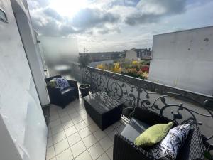 a balcony with chairs and a view of a city at ALP Chartres - Grand studio avec terrasse et parking in Chartres