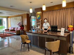 a woman wearing a mask in a hotel lobby at Gueylin Hotel in Luzhu