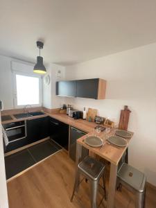 a kitchen with a wooden table with four chairs at ALP Chartres - Grand studio avec terrasse et parking in Chartres