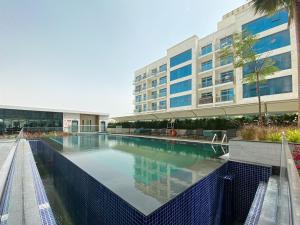 a swimming pool in front of a building at Perfect Studio in Arjan in Dubai