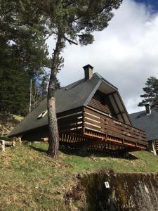 duży drewniany dom z czarnym dachem w obiekcie Chalet lac de Payolle w mieście Ancizan