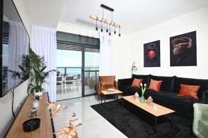 a living room with a black couch and a table at Kineret sheli- 4Bedrooms luxury apartment with stunning lake view in Tiberias