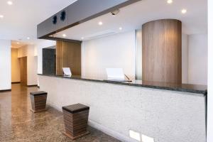 a lobby with a counter with two laptops on it at HOTEL MYSTAYS Nishi Shinjuku in Tokyo