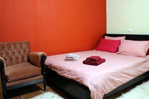 ein Schlafzimmer mit einem Bett mit einem Stuhl und einem Bett mit roten Wänden in der Unterkunft Snow story 1 -Elati, Trikala-2BD in Elati, Trikala