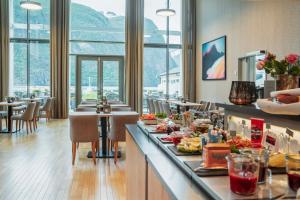 a restaurant with food on a counter with tables at Valldal Fjordhotell - by Classic Norway Hotels in Valldal