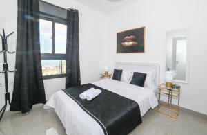 a bedroom with a large white bed with a window at Kineret sheli- 4Bedrooms luxury apartment with stunning lake view in Tiberias