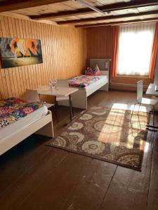 um quarto com duas camas e uma mesa e uma janela em Hotel Schönbrunnen em Münchenbuchsee