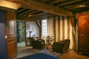 a room with striped walls with chairs and a table at La Maison des Corporations in Noyers