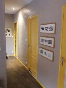 un couloir avec une porte jaune dans une chambre dans l'établissement Ahoma, séjour bien-être, calme et sérénité., à Labruguière