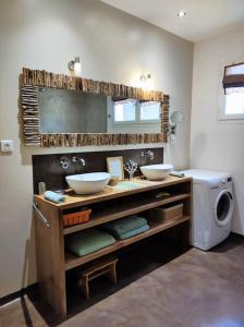 ein Badezimmer mit 2 Waschbecken und einer Waschmaschine in der Unterkunft Ahoma, séjour bien-être, calme et sérénité. in Labruguière